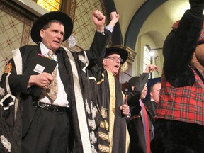 Jim Leech, centre, newly installed as the 14th chancellor of Queen's University, joins principal Daniel Woolf, left, and the university mascot in an Oil Thigh at the end of the fall convocation in Grant Hall. TUES., NOV 18, 2014 KINGSTON, ONT. MICHAEL LEA THE WHIG STANDARD QMI AGENC
