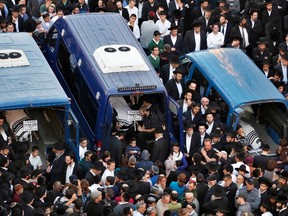 The bodies of Aryeh Kopinsky (C), Calman Levine (L) and Avraham Shmuel Goldberg lie in vehicles during their funeral near the scene of an attack at a Jerusalem synagogue, November 18, 2014. (REUTERS/Baz Ratner)