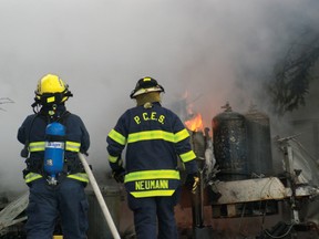 PCES members douse the flames of a trailer fire just north of Castle Mountain on Tuesday afternoon. Greg Cowan photo/QMI Agency.