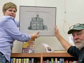 Ches Sulkowski (right) sets up his art exhibition at the Tillsonburg Public Library (OCL) Wednesday afternoon. The six-week show, which includes 11 sketches of historical Tillsonburg buildings, is being offered by Oxford Creative Connections Inc., which features artists from around Oxford County. Helping Sulkowski set up is Mary-Anne Murphy, Oxford Creative Connections Inc. cultural coordinator. (CHRIS ABBOTT/TILLSONBURG NEWS)