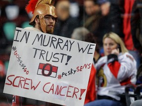 A hockey fan with a sign of support for Bryan Murray the Ottawa Senators general manager, who has Stage 4 cancer before the Calgary Flames, Ottawa Senators NHL hockey  game in Calgary, Alta. on Saturday November 15, 2014. Al Charest/Calgary Sun/QMI Agency