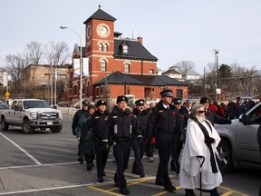 Rev. Sandra Tankard marches with veterans, uniformed police and first responders during the parade form Kenora Legion Branch 12 to the First World War cenotaph at Memorial Park during Remembrance Day services on November 11, 2014. (REG CLAYTON/QMI Agency)