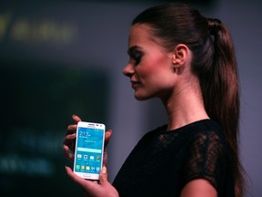 A model holds a Samsung Galaxy Alpha smartphone during a launch event in Jakarta, Aug. 28, 2014.  REUTERS/Beawiharta