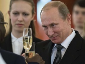 Russian President Vladimir Putin toasts with ambassadors in the Alexander Hall after a ceremony of presentation of credentials by foreign ambassadors in the Grand Kremlin Palace in Moscow on November 19, 2014.