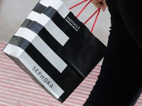 A woman walks with a Sephora shopping bag as she leaves a Sephora store in Paris July 23, 2014. REUTERS/Philippe Wojazer