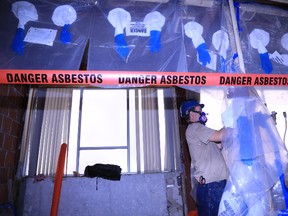 Rory O'Rourke carries out asbestos cleanup in an area which once served as a public washroom at Hastings County's Pinnacle Street administration building. Jason Miller/The Intelligencer