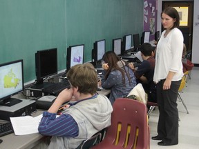 LCVI teacher Michelle Leake looks over her students' work as they take part in a workshop on geographic information systems - using data to plot information on maps. Workshops were also held at Queen's University. WED., NOV. 19, 2014 KINGSTON, ONT., MICHAEL LEA THE WHIG STANDARD QMI AGENCY