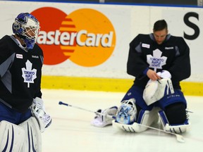James Reimer skates past a fellow goaltender Jonathan Bernier adjusts his mask at Maple Leafs practice on Wednesday. (Dave Abel/Toronto Sun)