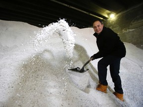 Councillor Denzil Minnan-Wong shovels a massive pile of road salt on Thursday Nov. 20, 2014. (CRAIG ROBERTSON/Toronto Sun)