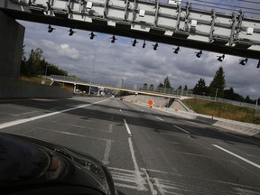 A vehicle approaches  an overpass holding the cameras that are part of the electronic toll bridge just west of the 10-lane cable-stayed Port Mann Bridge spanning the Fraser River connecting Coquitlam and Surrey in Vancouver's lower mainland on Wednesday Oct, 1, 2014. FILE