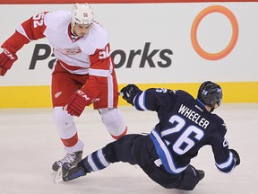 Detroit Red Wings defenceman Jonathan Ericsson (l) dumps Winnipeg Jets right winger Blake Wheeler during NHL hockey in Winnipeg, Man. Thursday, November 20, 2014.
Brian Donogh/Winnipeg Sun/QMI Agency