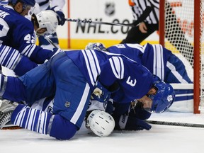 Maple Leafs' Dion Phaneuf jumps on top Tampa Bay's Steven Stamkos during Thursday's game in Toronto. (STAN BEHAL/TORONTO SUN)