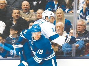 Maple Leafs fourth-liner Richard Panik checks Tampa’s Brett Connolly into the boards on Thursday. Panik scored his fourth of the season as the Leafs won 5-2. (Stan Behal/Toronto Sun)