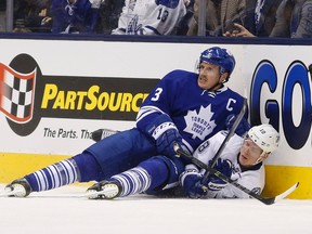 Maple Leafs captain Dion Phaneuf takes a seat atop Tampa Bay Lightning forward Odrej Palat on Thursday night in Toronto. (STAN BEHAL/TORONTO SUN)