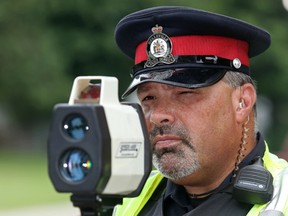 Belleville Police Const. Rob Travers uses a laser system to monitor the speeds of motorists on College Street East in Belleville, Ont. Tuesday, September 2, 2014. Each year police increase traffic enforcement during the first week of school in an attempt to slow down drivers and break such bad habits as distracted driving. Luke Hendry/The Intelligencer/QMI Agency