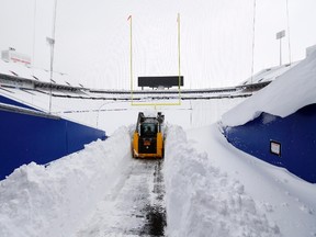 A grounds crew worker begins to clear snow from the football field at Ralph Wilson Stadium following a major storm in the area. (Kevin Hoffman/USA TODAY Sports)