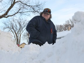Transcona resident Robert Denniston peers over windrows left by plows that blocked his lane last winter. The city's public works committee will discuss windrows on Tuesday. (Brian Donogh/Winnipeg Sun file photo)