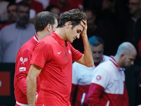 Switzerland's Roger Federer reacts next to his Davis Cup captain Severin Luthi after he lost his singles tennis match against France's Gael Monfils at the Pierre-Mauroy stadium in Villeneuve d'Ascq November 21, 2014.     (REUTERS/Gonzalo Fuentes)
