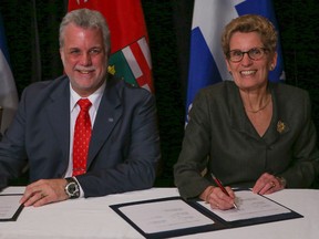 Ontario Premier Kathleen Wynne along with Quebec Premier Philippe Couilard, announce a new deal between the two provinces on selling and buying electric power in Toronto on Nov. 21, 2014. (Dave Thomas/Toronto Sun)