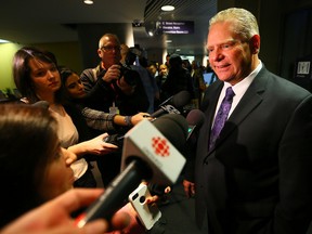 Doug Ford speaks to the media as the Rob Ford Bobble heads go on sale for the last time at City Hall on Nov. 21, 2014. (Dave Abel/Toronto Sun)