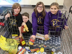 Rideau Heights Public School students Ty Everett, Parker Everett, Madison Gingrich and Taryn Grillet look through the collection bin holding the food donated so far during a food drive for the Partners in Mission Food Bank. Seven elementary schools are participating. FRI., NOV. 21, 2014 KINGSTON, ONT. MICHAEL LEA THE WHIG STANDARD QMI AGENCY