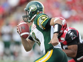 Mike Reilly eludes Calgary's Deroy Mayo during a recent game in Calgary (Al Charest, QMI Agency).