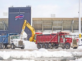 Workers clear snow outside of Ralph Wilson Stadium on Friday. (REUTERS)