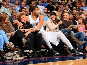 JaVale McGee #34 of the Denver Nuggets protects the fans as he ended up in the front row after saving the ball against the New Orleans Pelicans at Pepsi Center on November 21, 2014 in Denver, Colorado. (Doug Pensinger/Getty Images/AFP)