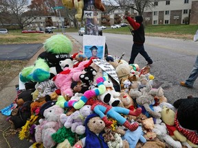 Michael Brown Sr. walks past the memorial set up where his son Michael Brown was shot and killed as he delivers donated food in Ferguson, Missouri, November 22, 2014.  REUTERS/Jim Young