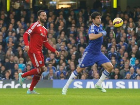 Chelsea's Diego Costa (R) is watched by West Bromwich Albion's Joleon Lescott as he scores a goal during their English Premier League soccer match at Stamford Bridge in London November 22, 2014. (REUTERS/Suzanne Plunkett)