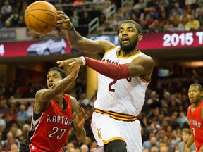 Cleveland Cavaliers' Kyrie Irving passes while under pressure from Raptors' Lou Williams on Saturday night at Quicken Loans Arena in Cleveland. (GETTY IMAGES)