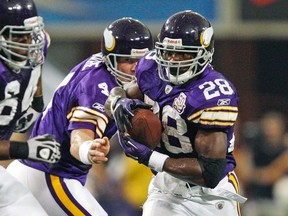 Minnesota Vikings quarterback Brett Favre (C) hands the ball off to Minnesota Vikings running back Adrian Peterson (R) behind Vikings guard Anthony Herrera (L) during the fourth quarter of their NFC, NFL football game against the Miami Dolphins in Minneapolis, September 19, 2010. (REUTERS/Eric Miller)