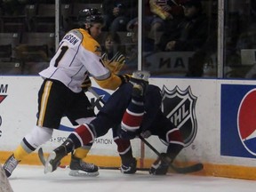 Hayden Hodgson of the Sarnia Sting tosses Greg DiTomaso of the Saginaw Spirit into the boards during OHL action Sunday in Sarnia. The Sting rallied from three different deficits to win 5-3. (TERRY BRIDGE/THE OBSERVER)