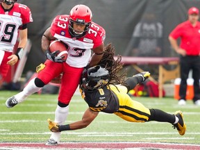 Calgary Stampeders' Hugh Charles (33) scrambles forward for a first down escaping the tackle attempt by Hamilton Tiger-Cats' Rico Murray in the first half of their CFL football game in Hamilton August 16, 2014. (REUTERS/Fred Thornhill)