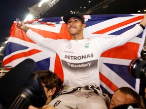 Mercedes Formula 1 driver Lewis Hamilton of Britain celebrates with his team after winning the Abu Dhabi Grand Prix yesterday to clinch his second drivers’ world championship. (REUTERS)