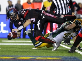 Bo Levi Mitchell is tacked by the Edmonton Eskimos at McMahon Stadium on Nov. 23, 2014. Photo by Calgary Sun.