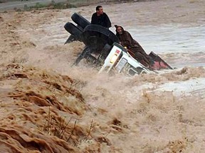Drivers and a truck are stranded in flood waters  November 22, 2014 2014 in the southern region of  Ouarzazate in Morocco.  At least eight people were killed and 24 were missing as heavy storms lashed southern Morocco, causing flash floods, the authorities said.  Flash floods are common in Morocco, where four children drowned in the south in September when they were swept away. AFP PHOTO / STR