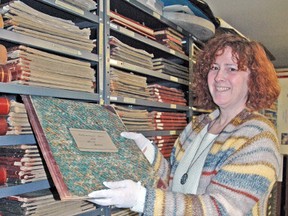 Ellen Charendoff, archivist with the Mitchell branch of the Stratford-Perth Archives, is preparing to pack the local archive collections, including this assessment roll from 1899, for the move to their new building in Stratford in 2015. After nearly 30 years in town, the Mitchell branch is set to close this Friday, Nov. 28.  KRISTINE JEAN/MITCHELL ADVOCATE