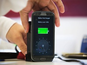 A lab worker disconnects from a charger a mobile phone, displaying a timer indicating that the battery was fully charged under 30 seconds, at the headquarters of StoreDot in Tel Aviv Oct. 23, 2014.  REUTERS/Finbarr O'Reilly