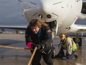 Lia Grimanis, CEO of Up With Women, attempts to pull a 13,600-kilogram Bombardier 605 Challenger jet 25 metres at Pearson International Airport on Monday, November 24, 2014. (Ernest Doroszuk/Toronto Sun)