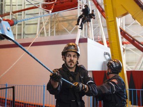Members of Edmonton Fire Rescue Services Technical Rescue Team train on the Mindbender roller coaster at West Edmonton Mall's Galaxyland in Edmonton, Alta., on Monday, Nov. 24, 2014. Firefighters spent the morning doing high angle rescue training on the structure, using ropes and pulleys. Three people died on the Mindbenders in 1986 after an accident. Ian Kucerak/Edmonton Sun