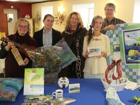 Nona Mariotti, Christine Spicer, Doreen Morey, Ann Barlow and David Townsend show some of the items that will go on the auction block during an auction and night of entertainment and food tasting Nov. 28 at the Grace Centre in Sydenham to benefit the seniors' programs of the Southern Frontenac Community Services. (Michael Lea/The Whig-Standard)