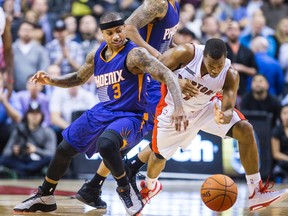 Isaiah Thomas of the Phoenix Suns (left) collides with Kyle Lowry of the Toronto Raptors during the second half at the Air Canada Centre on Nov. 24, 2014. (ERNEST DOROSZUK/Toronto Sun)