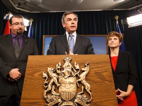 Premier Jim Prentice (centre) speaks beside Ian Donovan (left) and Kerry Towle (right) during a press conference at the Alberta Legislature announcing Donovan and Towle as new Progressive Conservative MLAs. Both crossed the floor from the Wildrose on Monday, Nov. 24, 2014. 
Ian Kucerak/Edmonton Sun/ QMI Agency