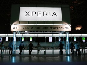 A signboard displaying the logo of Sony Corp's smartphone line Xperia is seen above its booth as visitors try out game applications on the devices during the Tokyo Game Show 2014 in Makuhari, east of Tokyo Sept. 18, 2014. REUTERS/Yuya Shino