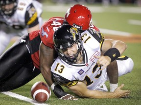 Shawn Lemon of the Stampeders brings down Tiger-Cats QB Dan LeFevour during CFL action in Calgary on July 18, 2014. The Stamps meet the Ticats for the Grey Cup on Sunday in Vancouver. (Lyle Aspinall/QMI Agency/Files)