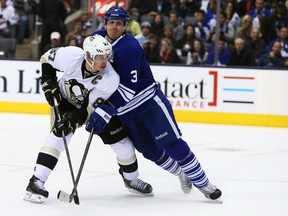 Dion Phaneuf of the Toronto Maple Leafs battles for the puck with Sidney Crosby of the Pittsburgh Penguins at the Air Canada Centre in Toronto on Oct. 26, 2013. (DAVE ABEL/Toronto Sun)