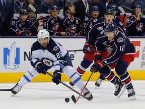 Nov 25, 2014; Columbus, OH, USA; Winnipeg Jets center Mathieu Perreault (85) and Columbus Blue Jackets left wing Matt Calvert (11) battle for the puck during the first period at Nationwide Arena. Mandatory Credit: Russell LaBounty-USA TODAY Sports