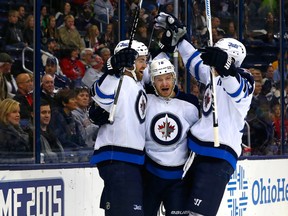 Nov 25, 2014; Columbus, OH, USA; Winnipeg Jets center Bryan Little (18) celebrates a goal against the Columbus Blue Jackets with teammate Andrew Ladd (left) and Blake Wheeler (right) during the first period at Nationwide Arena. Mandatory Credit: Russell LaBounty-USA TODAY Sports