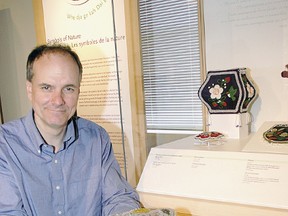 Elgin County Museum curator Michael Baker displays beadwork from the museum's collection.